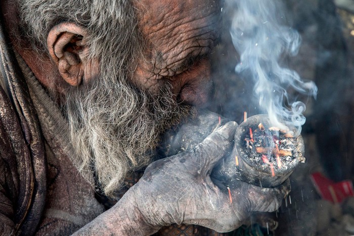 Amou Haji (uncle Haji) smokes from his waterpipe as he sits on the ground on the outskirts of the village of Dezhgah in the Dehram district of the southwestern Iranian Fars province, on December 28, 2018. - Believed to be the worlds dirtiest man, villagers say that Haji's leather-like skin hasn't touched soap and water for more than sixty years. They believe that he decided to live in isolation after suffering from an emotional setback in his youth. (Photo by - / AFP) (Photo by -/AFP via Getty Images)