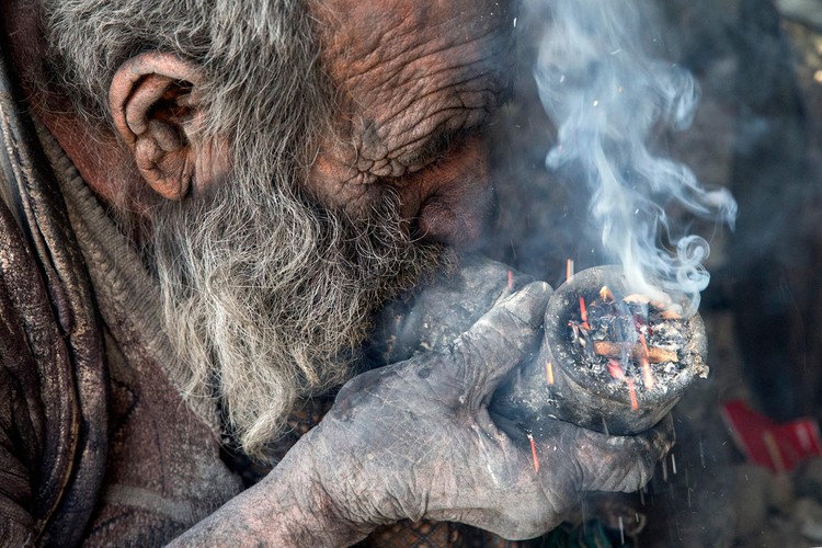 Amou Haji (uncle Haji) smokes from his waterpipe as he sits on the ground on the outskirts of the village of Dezhgah in the Dehram district of the southwestern Iranian Fars province, on December 28, 2018. - Believed to be the worlds dirtiest man, villagers say that Hajis leather-like skin hasnt touched soap and water for more than sixty years. They believe that he decided to live in isolation after suffering from an emotional setback in his youth. (Photo by - / AFP) (Photo by -/AFP via Getty Images)