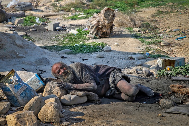 Amou Haji (uncle Haji) smokes from his waterpipe as he sits on the ground on the outskirts of the village of Dezhgah in the Dehram district of the southwestern Iranian Fars province, on December 28, 2018. - Believed to be the worlds dirtiest man, villagers say that Haji's leather-like skin hasn't touched soap and water for more than sixty years. They believe that he decided to live in isolation after suffering from an emotional setback in his youth. (Photo by - / AFP) (Photo by -/AFP via Getty Images)