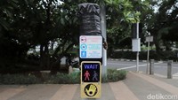 Tiang yang masih tersisa hanya penjelasan penggunaan tombol untuk menyeberang di pelican crossing. Bagian tiang yang patah kini ditutup plastik berwarna hitam.