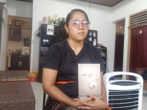 Putu Yanti Oktaviani (32) menunjukkan foto anaknya, Komang Dyra Bulan Kayana, bayi perempuan berusia 1 tahun yang meninggal dunia di RSUP Prof Ngoerah Denpasar setelah didiagnosis menderita gangguan ginjal akut misterius.