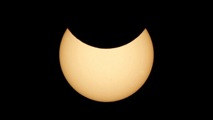 The moon covering part of the sun, during a partial solar eclipse at the monument of Soviet Marshal Georgy Zhukov in Moscow, Russia, Tuesday, Oct. 25, 2022. (AP Photo/Victor Berezkin)