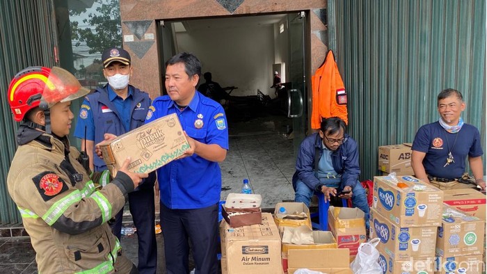 Warga memberikan semangat kepada petugas damkar di lokasi kebakaran gudang tripleks di Bandung.