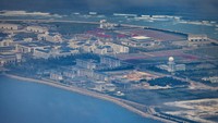 Terlihat sebuah area yang tampak seperti kota kecil dengan gedung bertingkat, gudang, hanggar, pelabuhan laut, serta landasan pacu.