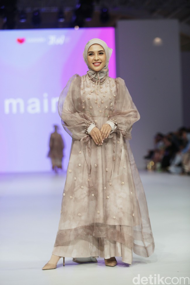 Ibu dua anak ini tampil elegan memakai hijab segi empat bahan voal yang diikat rapi ke belakang agar memperlihatkan detail dress lengan balon. Ia juga menambahkan scarf bahan transparan di kepala. Foto: Agung Pambudhy/Detikcom.