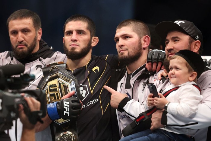 Islam Makhachev (2nd-L) poses for a picture with his coach Khabib Nurmagomedov (2nd-R) and Russian social media star Hasbulla Magomedov (R) after defeating Charles Oliveira in the lightweight championship at the Ultimate Fighting Championship (UFC) event at the Etihad Arena in Abu Dhabi on October 22, 2022. (Photo by Giuseppe CACACE / AFP) (Photo by GIUSEPPE CACACE/AFP via Getty Images)