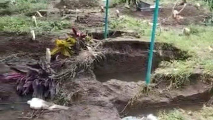 Liang lahad makam yang menyembul usai diterjang banjir bandang