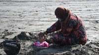 Para orang tua di Pakistan percaya mengubur tubuh anak yang sedang sakit di dalam pasir saat gerhana matahari dapat menyembuhkan penyakit. Sabir Mazhar/Anadolu Agency/Getty Images