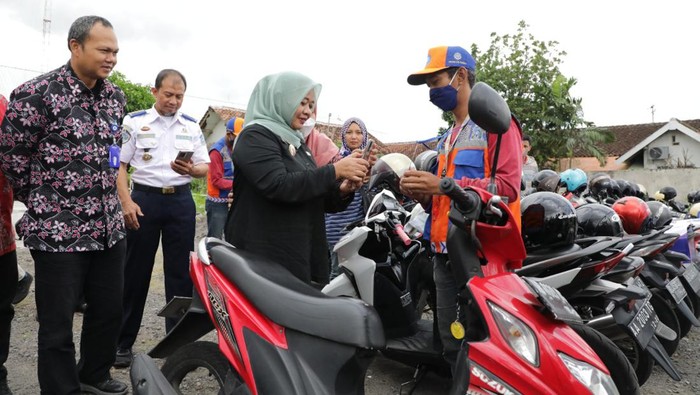 Bupati Sleman Kustini Sri Purnomo saat mencoba membayar parkir dengan scan QRIS.