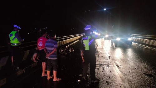 Petugas Polsek Kerambitan melakukan olah TKP kecelakaan   motor dan truk di Jembatan Samsam, Banjar Penyalin, Desa Samsam, Kerambitan, Tabanan, Bali, Kamis dini hari (27/10/2022).