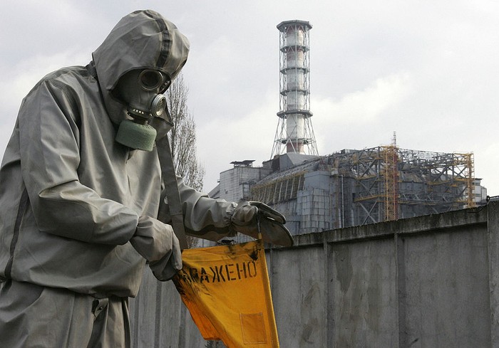 Chernobyl, UKRAINE:  A rescue worker sets flag signalling radioactivity in front of Chernobyl nuclear power plant during a drill organized by Ukraines Emergency Ministry 08 November 2006. Employees and rescue workers improved their reactivity in case of a collapse of the sarcophagus covering the destroyed 4th power block. AFP PHOTO/ SERGEI SUPINSKY  (Photo credit should read SERGEI SUPINSKY/AFP via Getty Images)