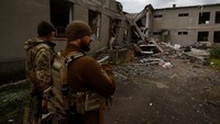 Prajurit Ukraina berdiri di samping gedung sekolah yang dihancurkan oleh serangan udara Rusia di sebuah desa dekat garis depan di wilayah Mykolaiv, Ukraina 26 Oktober 2022.