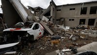 Seekor anjing berdiri di antara puing-puing gedung sekolah yang hancur akibat serangan udara Rusia di sebuah desa dekat garis depan di wilayah Mykolaiv, Ukraina, 26 Oktober 2022.