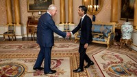 Foto-foto yang didistribusikan oleh Istana Buckingham menunjukkan Raja Charles III menjabat tangan Sunak saat dia mengangkatnya menjadi perdana menteri kulit berwarna pertama di Inggris. Aaron Chown/REUTERS