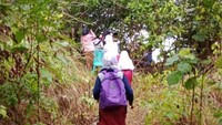 Para siswa SDN 011, Desa Matude, Lingga, Kepri tengah mendaki bukit agar mendapatkan akses internet yang memadai untuk ujian ANBK (Foto: Istimewa)