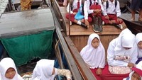 Siswa dan guru SD di Lingga, Kepri menyusuri hutan bakau menuju daerah yang memiliki akses internet stabil. Untuk menjangkau lokasi perbukitan agar mendapat sinyal internet mereka menumpangi sebuah kapal. (Foto: Istimewa)