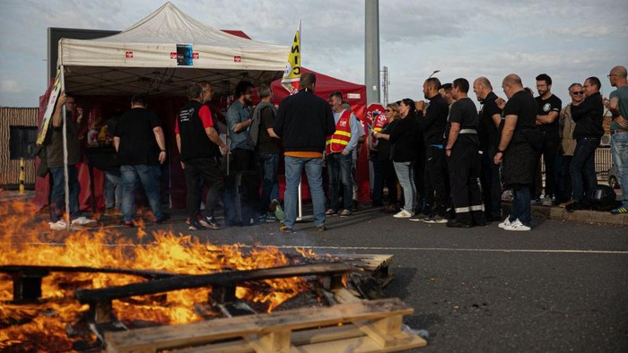 CGT Trade unionists and employees gather as they vote the strike reconduction at the TotalEnergies refinery site, in Gonfreville-l'Orcher, near Le Havre, northwestern France, on October 27, 2022. - Refinery employees voted to pursue the strike and 
