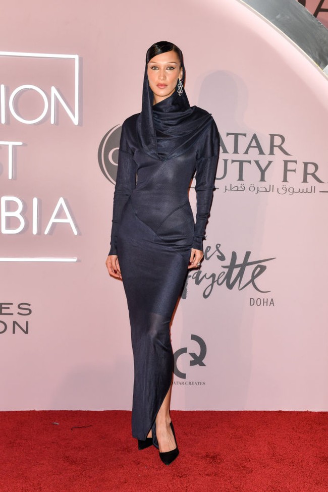 Bella Hadid datang dengan penampilan anggunnya. Ia mengenakan dress satin biru. Dress pas badan yang menunjukkan siluet tubuh Bella tersebut memiliki kesan modest karena berlengan panjang, begitu juga dengan area dadanya yang tertutup. Foto: Getty Images