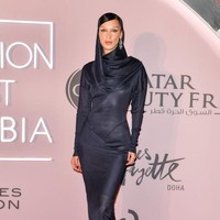 Bella Hadid datang dengan penampilan anggunnya. Ia mengenakan dress satin biru. Dress pas badan yang menunjukkan siluet tubuh Bella tersebut memiliki kesan modest karena berlengan panjang, begitu juga dengan area dadanya yang tertutup. Foto: Getty Images