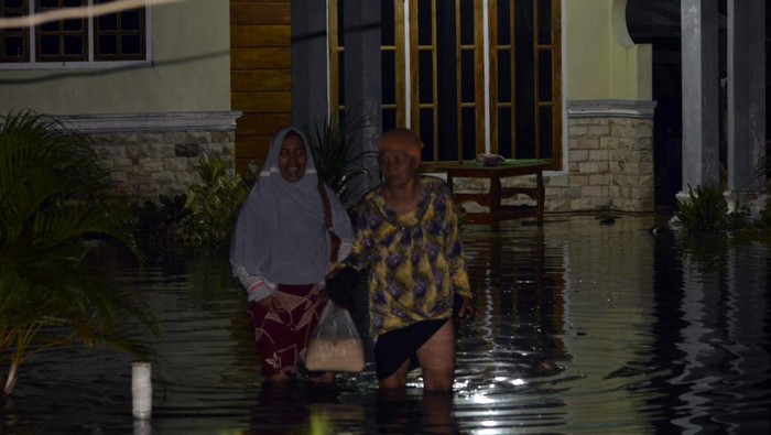 Desa di Lampung Selatan Terendam Banjir, Ratusan Orang Mengungsi Warga berjalan keluar dari rumahnya yang tergenang banjir akibat luapan Sungai Way Ketibung di Desa Beringin Kencana, Candipuro, Lampung Selatan, Lampung, Kamis (27/10/2022). Banjir tersebut terjadi akibat tanggul di sungai tersebut jebol dan merendam ratusan rumah penduduk, menyebabkan 200 orang mengungsi ke tempat yang lebih aman. ANTARA FOTO/Ardiansyah/wsj.