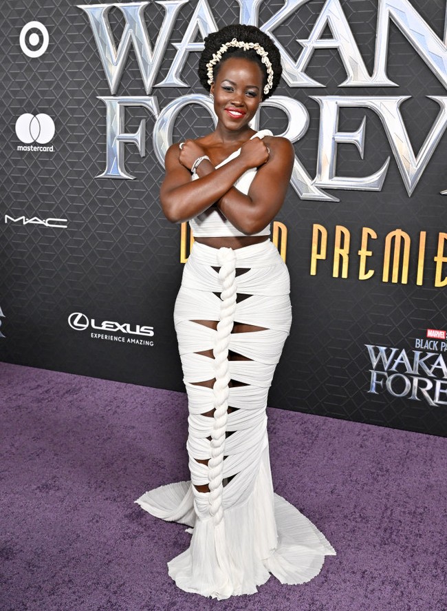 Lupita Nyong’o mencuri perhatian dengan gaun putih berdetail unik keluarah rumah mode Balmain. Gaun dengan aksen simpul dan pleats ini menonjolkan kecantikan kulit pemeran Nakia ini. Foto: FilmMagic/Axelle/Bauer-Griffin