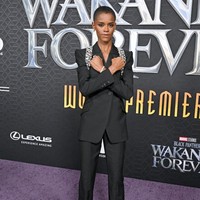 Letitia Wright memilih tampilan maskulin dengan setelan blazer hitam keluaran Alexander McQueen. Pemeran Shuri ini melengkapi gayanya dengan perhiasan statement. Foto: FilmMagic/Axelle/Bauer-Griffin