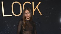 Hailey Bieber menyempurnakan penampilannya dengan sandal bertali silang, juga dari Saint Laurent. Foto: WWD via Getty Images/Michael Buckner