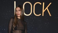 Hailey Bieber menjaga penampilannya tetap netral, memilih mata smoky yang halus, bibir kemerahan, dan kuku merah darah yang mengkilap. Foto: WWD via Getty Images/Michael Buckner