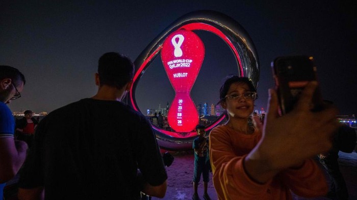 Visitors take pictures of the Qatar 2022 FIFA World Cup countdown clock as it marks thirty days for the start of the international football competition, in the Qatari capital Doha on October 20, 2022. (Photo by Jewel SAMAD / AFP) (Photo by JEWEL SAMAD/AFP via Getty Images)