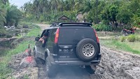 Mobil kesulitan melintasi di jalan rusak yang oleh warga sekitar dibangun kuburan. (Foto: Istimewa)