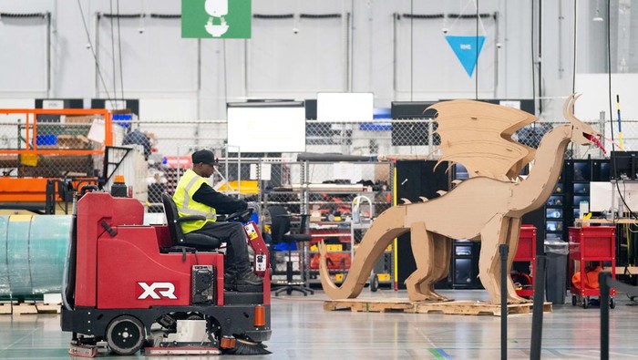 Oh... Ternyata Begini Toh Proses Sortir Paket di Amazon APPLING, GA - OCTOBER 27: A worker drives past a cardboard dragon at the Amazon AGS5 sort facility on October 27, 2022 in Appling, Georgia. Amazon, the leading United States retail e-commerce company is preparing for the busy winter holiday season and plans to hire 150,000 full-time, seasonal and part-time workers to fulfill orders. (Photo by Sean Rayford/Getty Images)