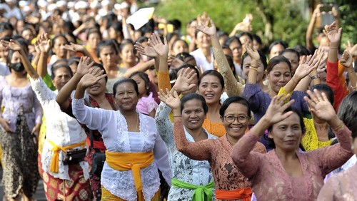 Sejumlah perempuan berjalan kaki sambil melambaikan tangan saat mengikuti parade kebaya di Desa Bongkasa, Badung, Bali, Jumat (28/10/2022). Para perempuan tersebut mendukung kampanye Gerakan Kebaya Goes to UNESCO.