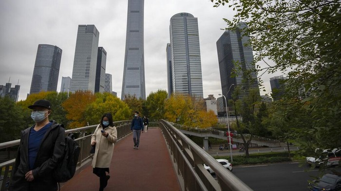 Potret Terbaru China Lockdown Lagi Gegara COVID-19 Menggila Commuters wearing face masks walk across a pedestrian bridge in the central business district in Beijing, Friday, Oct. 28, 2022. (AP Photo/Mark Schiefelbein)