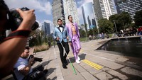 Seorang model memakai tongkat saat memperagakan busana kreasi desainer Meksiko di sebuah catwalk.