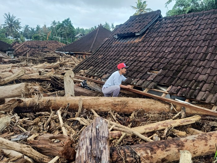 Salah seorang warga saat berusaha mencari barang berharga di dalam rumahnya, Jumat (28/10/2022).