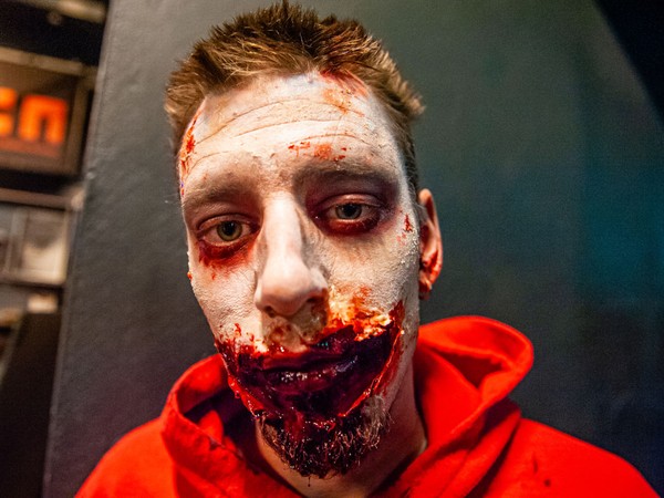 Salah satu pria yang menyerupai zombie ini berdandan seakan-akan mulutnya berlumuran darah.