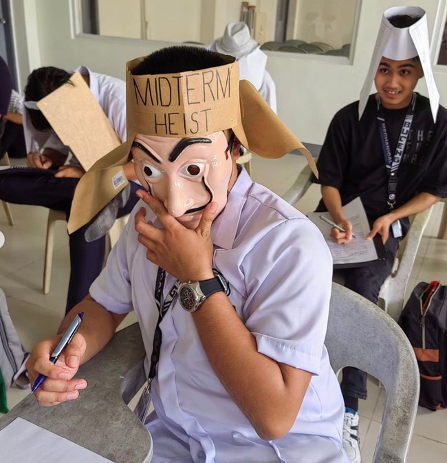 Bermodalkan topeng ala film Money Heist dan karton coklat tak terpakai, topi anti nyontek yang satu ini terlihat unik. Pada tahun 2013 sendiri Universitas Kasetsart di Thailand sempat viral karena menerapkan hal serupa. Foto: Instagram/@majjoymandz