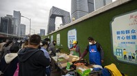Pedagang kaki lima yang memakai masker membuat makanan untuk dibawa pulang oleh para komuter di sebuah gerobak di kawasan pusat bisnis di Beijing. Partai Komunis yang berkuasa di China sejauh ini tidak menunjukkan tanda-tanda pelonggaran nol-COVID Kebijakan. AP/Mark Schiefelbein