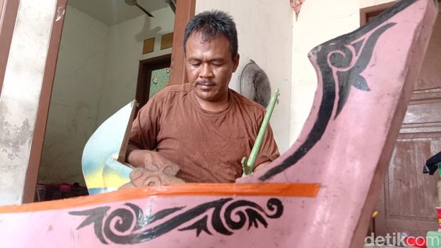 Darmin dan replika perahu buatannya.