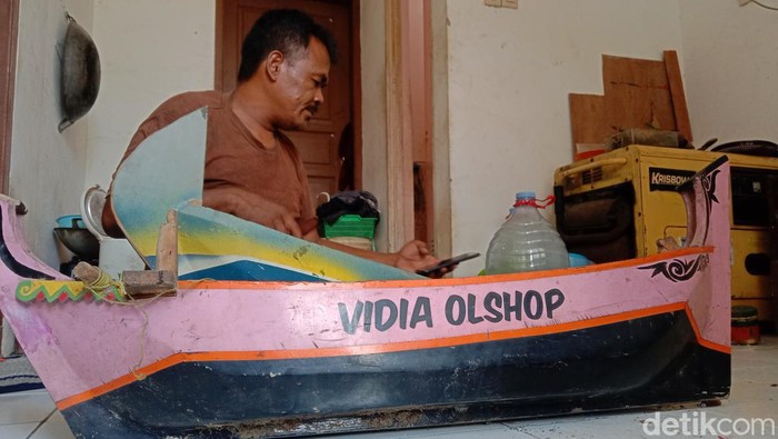 Darmin dan replika perahu buatannya.