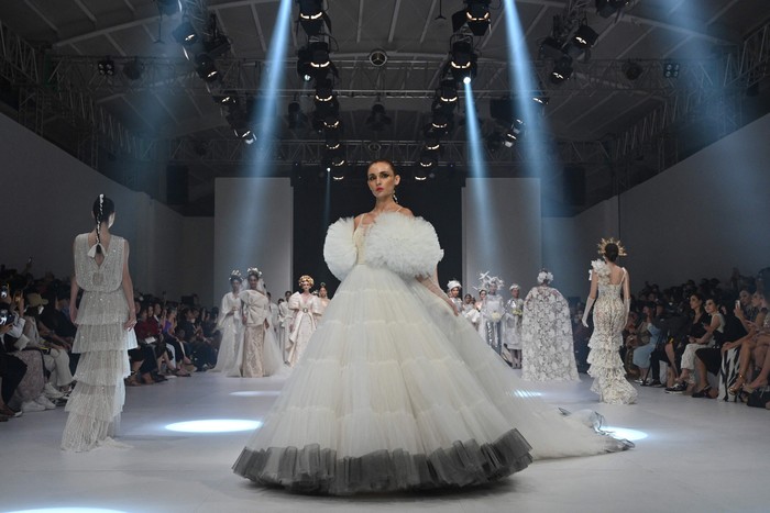 Koleksi Gaun Pengantin Karya Desainer IPMI di JFW 2023 This photo taken on October 28, 2022 shows models presenting creations from a group of twelve Indonesian designers entitled Moonlight Whispers during the 2023 Jakarta Fashion Week in Jakarta. (Photo by ADEK BERRY / AFP) (Photo by ADEK BERRY/AFP via Getty Images)