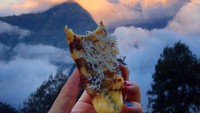  Menikmati hangatnya pisang goreng bertabur keju, Melissa ditemani pemandangan gunung Rinjani yang indah.  Foto: Instagram @girleatworld