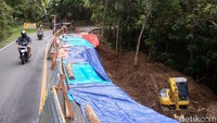 Pantauan detikJateng di lokasi jalan amblas, Minggu (30/10/2022) siang ini, bagian jalan yang amblas sudah ditutup terpal. Jalan yang amblas hampir mencapai ke tengah jalan. Foto: Pius Erlangga/detikJateng