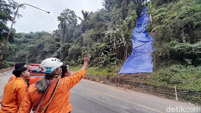 Pemasangan terpal di lokasi bekas longsoran Cadas Pangeran, Sumedang.