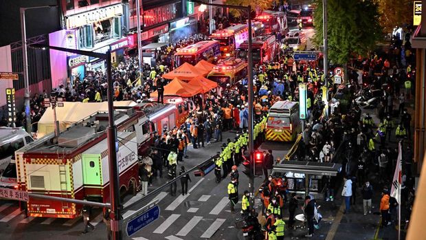 Kerumunan terlihat di sekitar area, di mana puluhan orang menderita serangan jantung usai pawai Halloween, di distrik kehidupan malam populer Itaewon di Seoul, Korea Selatan (30/10). (Photo by JUNG YEON-JE/AFP via Getty Images)