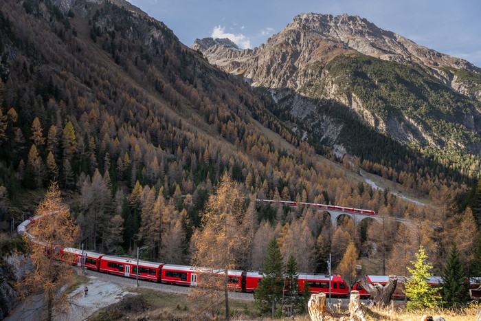 TOPSHOT - A 1910-metre-long train with 100 cars passes near Bergun, on October 29, 2022, during a record attempt by the Rhaetian Railway (RhB) of the Worlds longest passenger train, to mark the Swiss railway operators 175th anniversary. - The record attempt is carried out on the Albula Line, from Preda to Thusis, crossing one of the most spectacular railways in the world, recognised as a Unesco World Heritage Site. (Photo by Fabrice COFFRINI / AFP) (Photo by FABRICE COFFRINI/AFP via Getty Images)