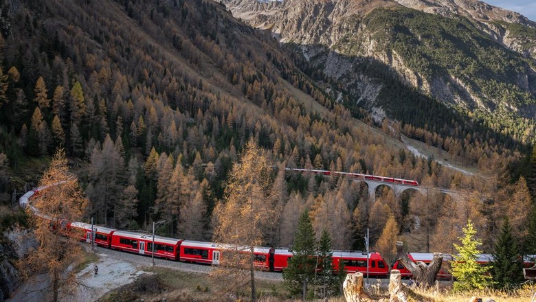 TOPSHOT - A 1910-metre-long train with 100 cars passes near Bergun, on October 29, 2022, during a record attempt by the Rhaetian Railway (RhB) of the Worlds longest passenger train, to mark the Swiss railway operators 175th anniversary. - The record attempt is carried out on the Albula Line, from Preda to Thusis, crossing one of the most spectacular railways in the world, recognised as a Unesco World Heritage Site. (Photo by Fabrice COFFRINI / AFP) (Photo by FABRICE COFFRINI/AFP via Getty Images)