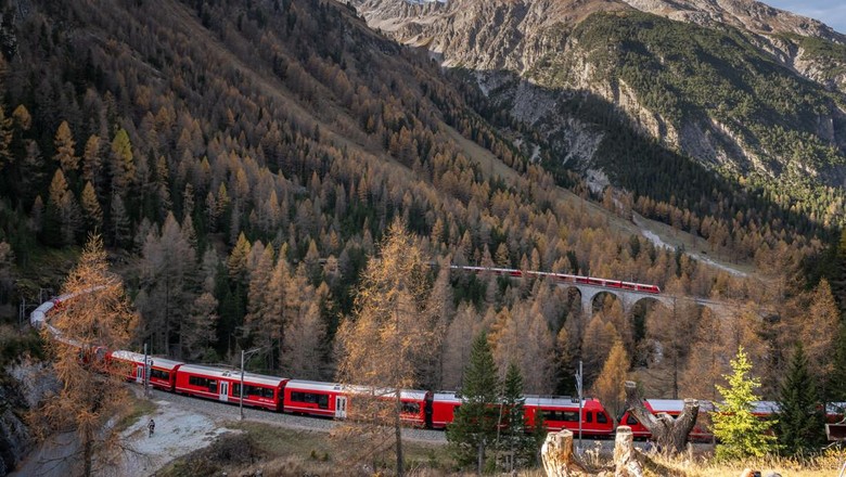 1244314103 TOPSHOT - A 1910-metre-long train with 100 cars passes near Bergun, on October 29, 2022, during a record attempt by the Rhaetian Railway (RhB) of the Worlds longest passenger train, to mark the Swiss railway operators 175th anniversary. - The record attempt is carried out on the Albula Line, from Preda to Thusis, crossing one of the most spectacular railways in the world, recognised as a Unesco World Heritage Site. (Photo by Fabrice COFFRINI / AFP) (Photo by FABRICE COFFRINI/AFP via Getty Images)