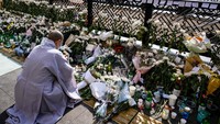 Banyak juga yang ikut memanjatkan doa dalam keheningan. Foto: AFP via Getty Images/ANTHONY WALLACE