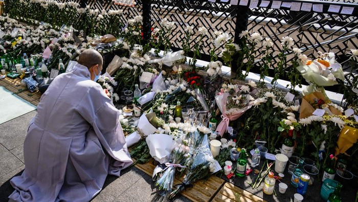 A nun kneels down to pray at a makeshift memorial outside a subway station in the district of Itaewon in Seoul on October 31, 2022, two days after a deadly Halloween surge in the area. (Photo by ANTHONY WALLACE / AFP) (Photo by ANTHONY WALLACE/AFP via Getty Images)
